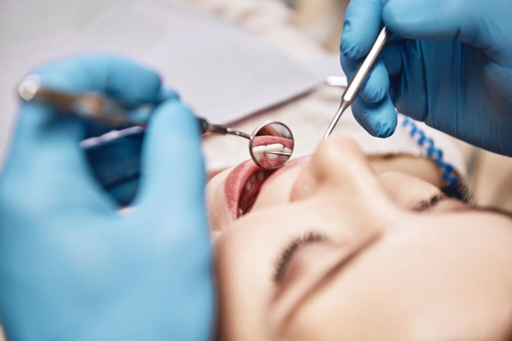 A woman having her teeth examined b y a dentist.